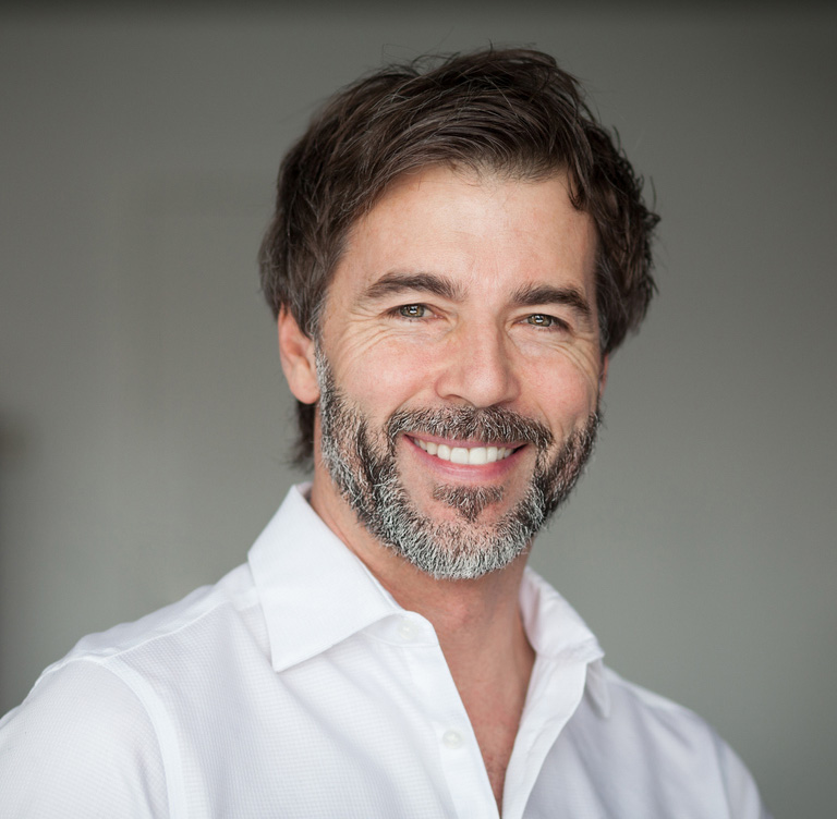Andre Nadeau wearing glasses and smiling at the camera
