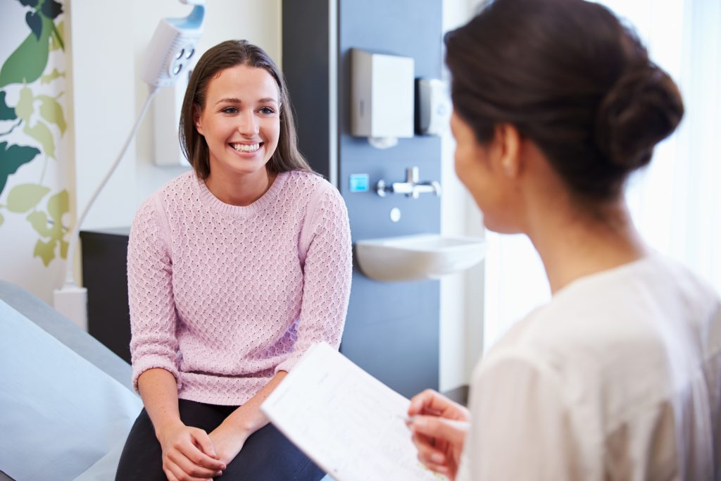 Provider speaking warmly with a female patient during a women's wellness consultation at a Tuscaloosa medspa.