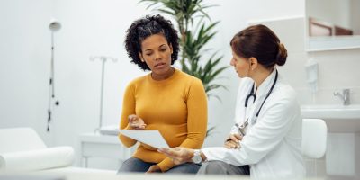 Woman consulting with a provider about PMOS symptoms at a women's wellness clinic in Tuscaloosa, Alabama.
