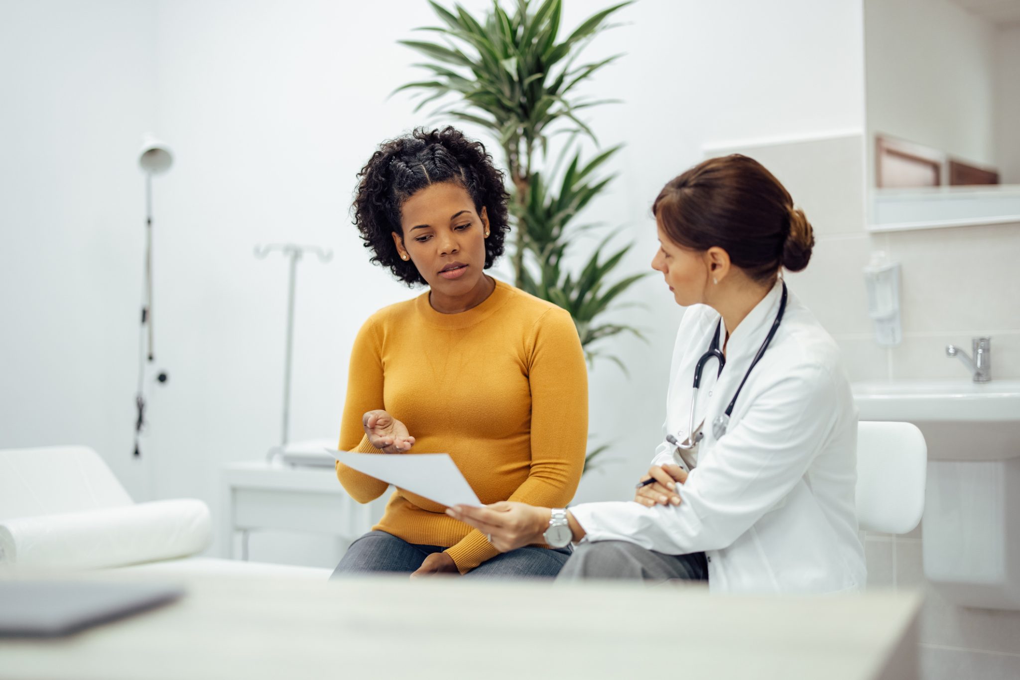 Woman consulting with a provider about PMOS symptoms at a women's wellness clinic in Tuscaloosa, Alabama.